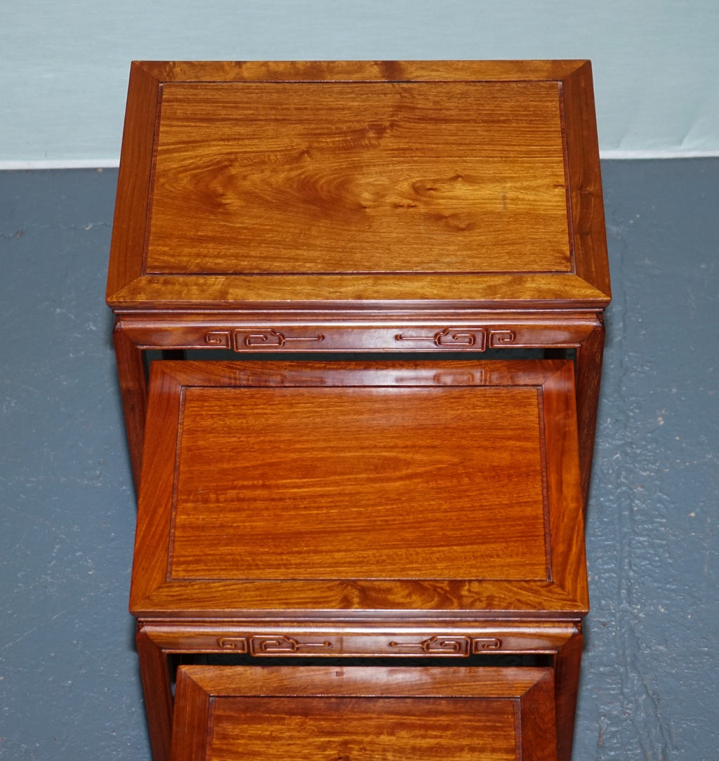 ORIENTAL CHINESE TEAK NEST OF FOUR TABLES WITH CARVED DETAILS
