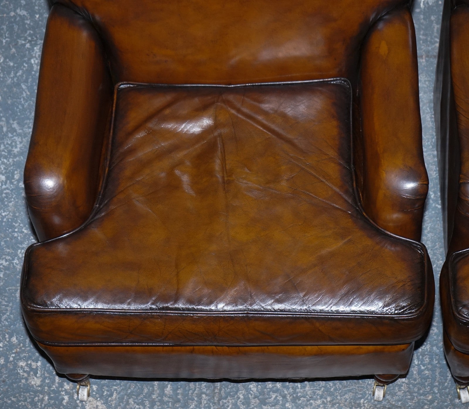 PAIR OF CIGAR HAND DYED LEATHER HOWARD & SONS STYLE ARMCHAIRS ON CASTOR FEET