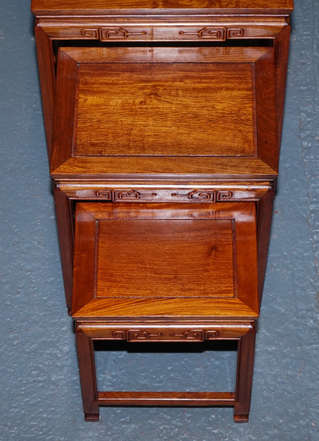ORIENTAL CHINESE TEAK NEST OF FOUR TABLES WITH CARVED DETAILS