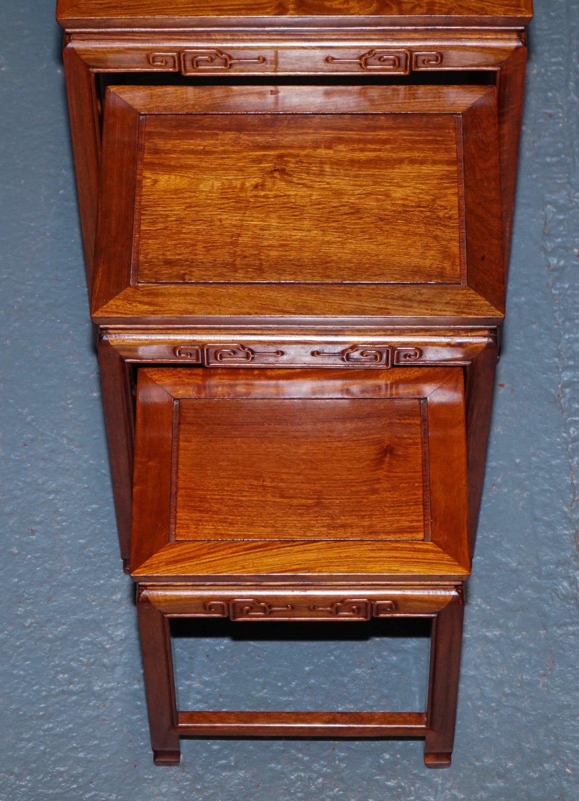 ORIENTAL CHINESE TEAK NEST OF FOUR TABLES WITH CARVED DETAILS