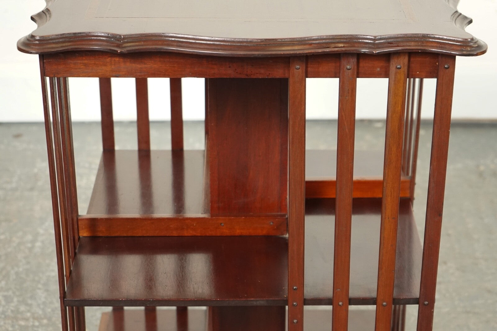 ANTIQUE EDWARDIAN REVOLVING BOOKCASE WITH A SERPENTINE SHAPED TOP
