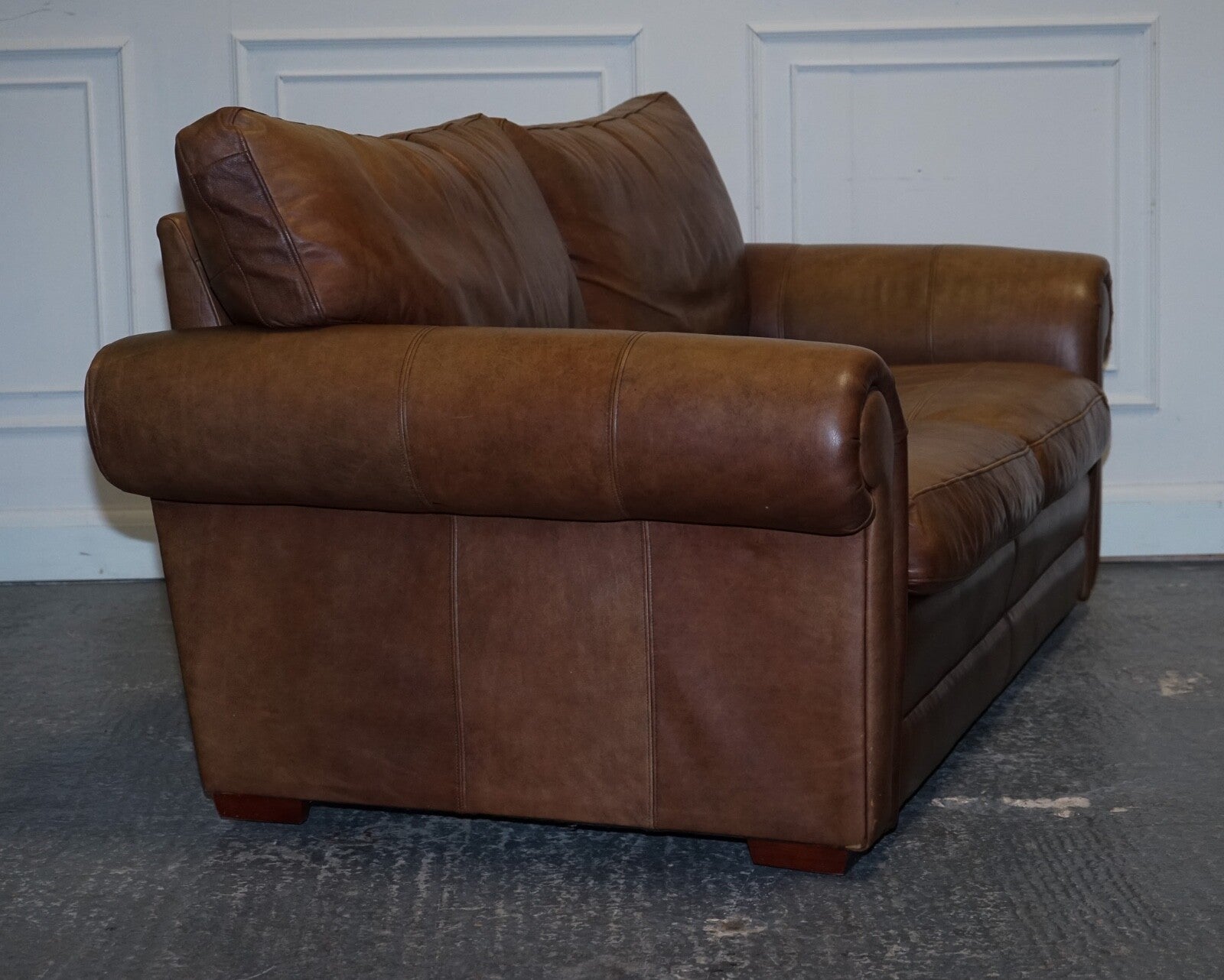 COMFORTABLE BROWN LEATHER TWO TO THREE SEATER SOFA WITH FEATHER BACK CUSHIONS