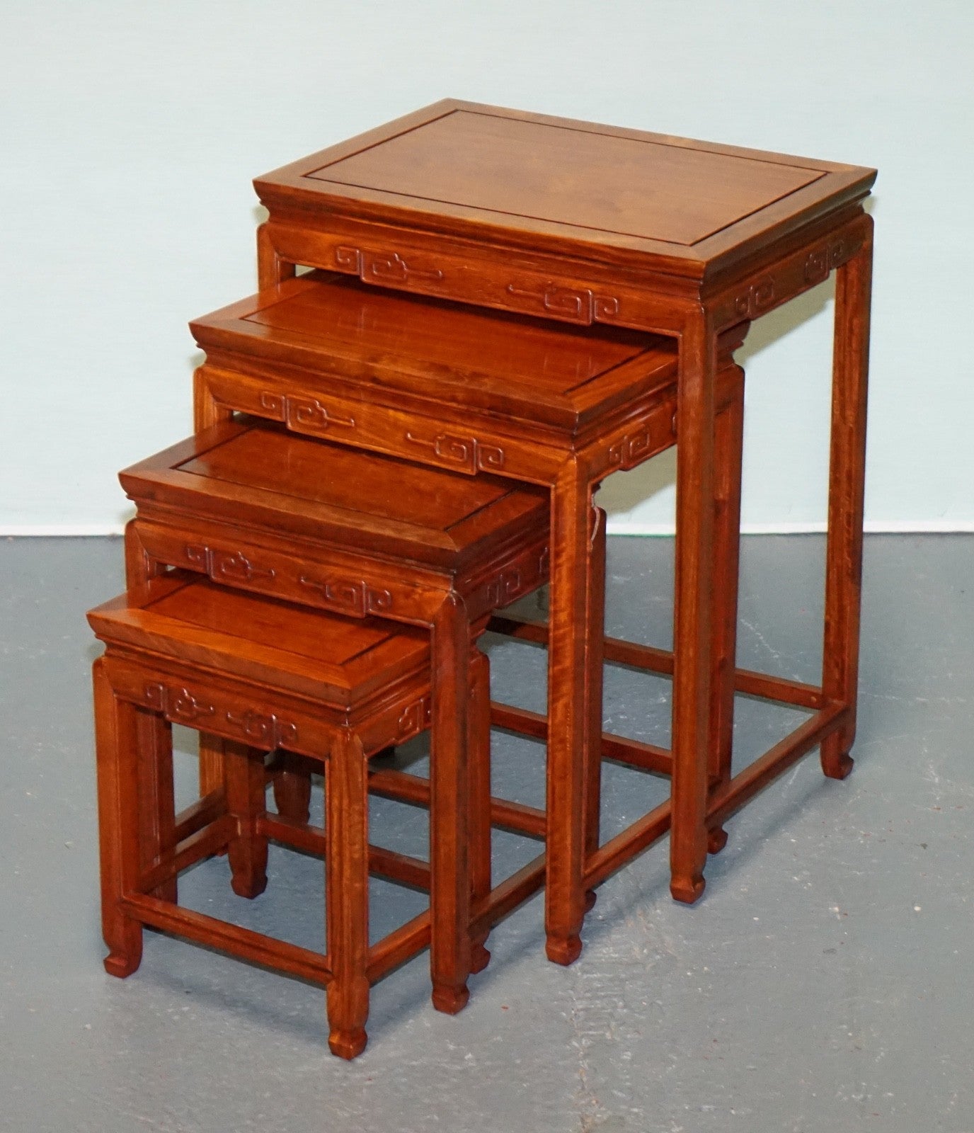 ORIENTAL CHINESE TEAK NEST OF FOUR TABLES WITH CARVED DETAILS