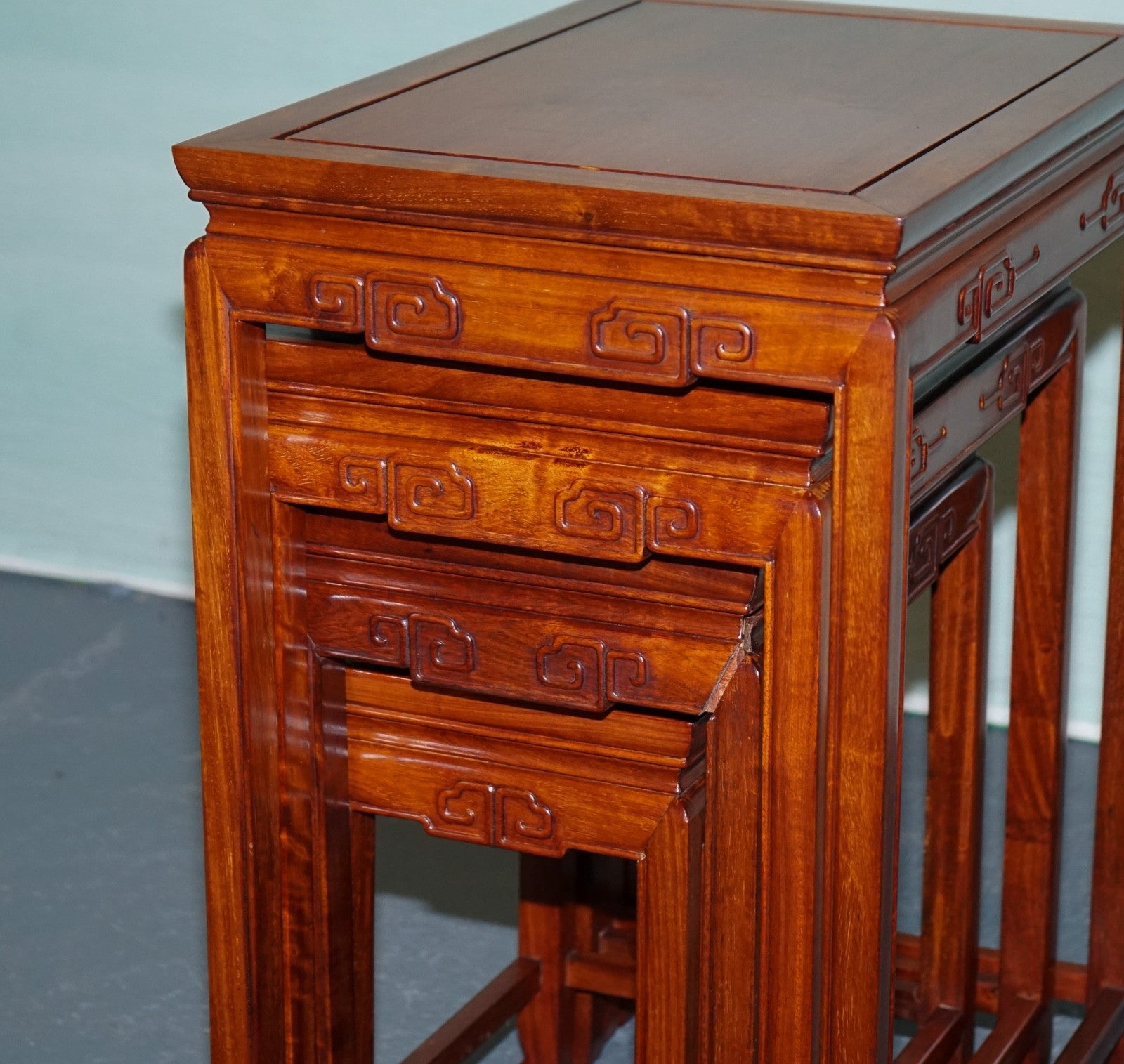 ORIENTAL CHINESE TEAK NEST OF FOUR TABLES WITH CARVED DETAILS
