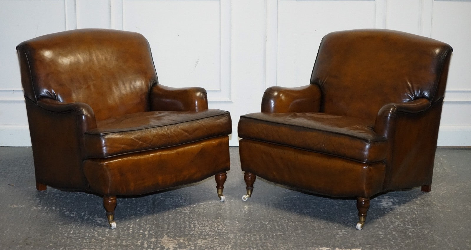 PAIR OF CIGAR HAND DYED LEATHER HOWARD & SONS STYLE ARMCHAIRS ON CASTOR FEET