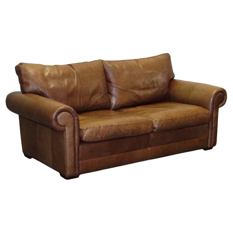 COMFORTABLE BROWN LEATHER TWO TO THREE SEATER SOFA WITH FEATHER BACK CUSHIONS