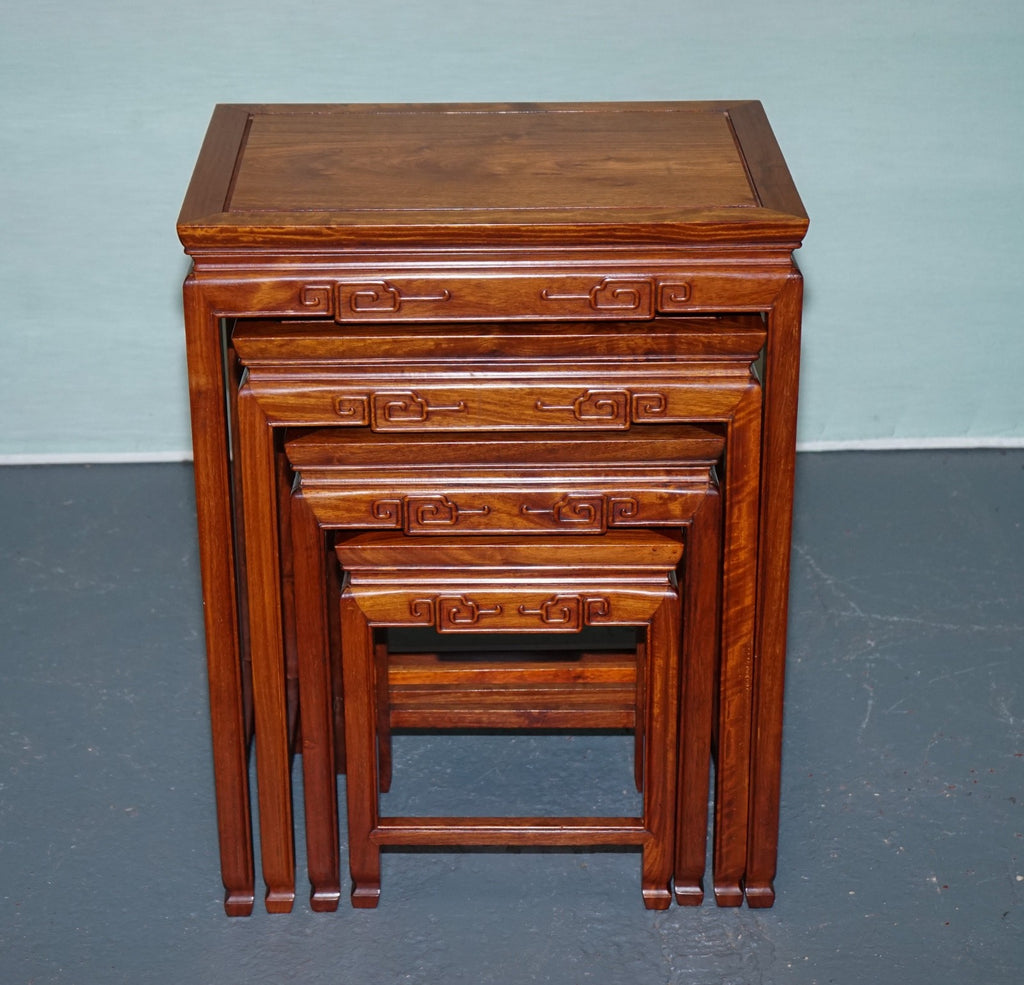 ORIENTAL CHINESE TEAK NEST OF FOUR TABLES WITH CARVED DETAILS