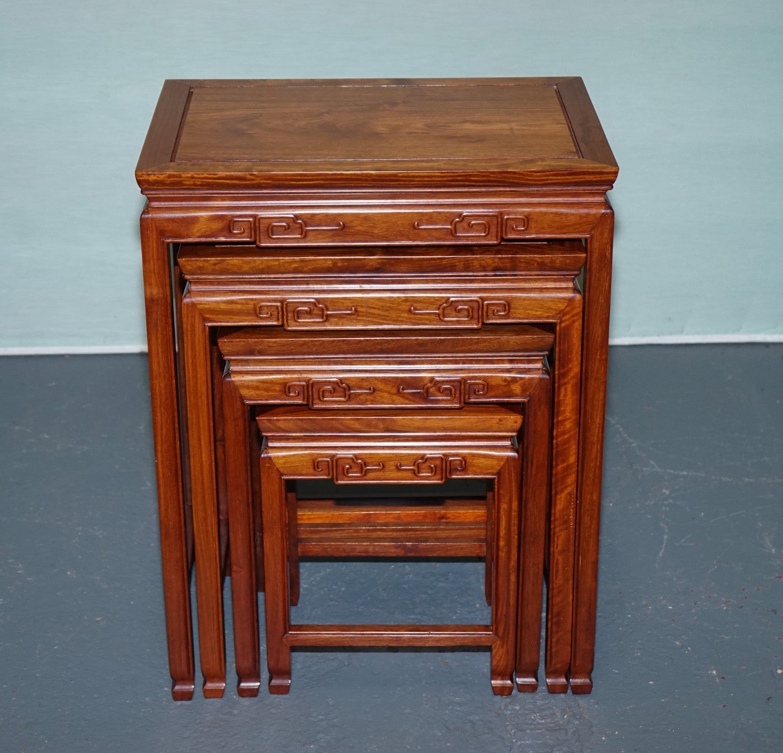 ORIENTAL CHINESE TEAK NEST OF FOUR TABLES WITH CARVED DETAILS