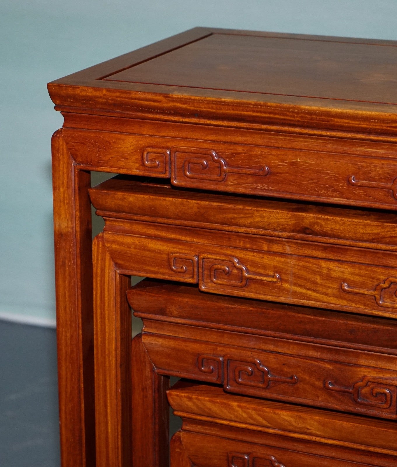 ORIENTAL CHINESE TEAK NEST OF FOUR TABLES WITH CARVED DETAILS