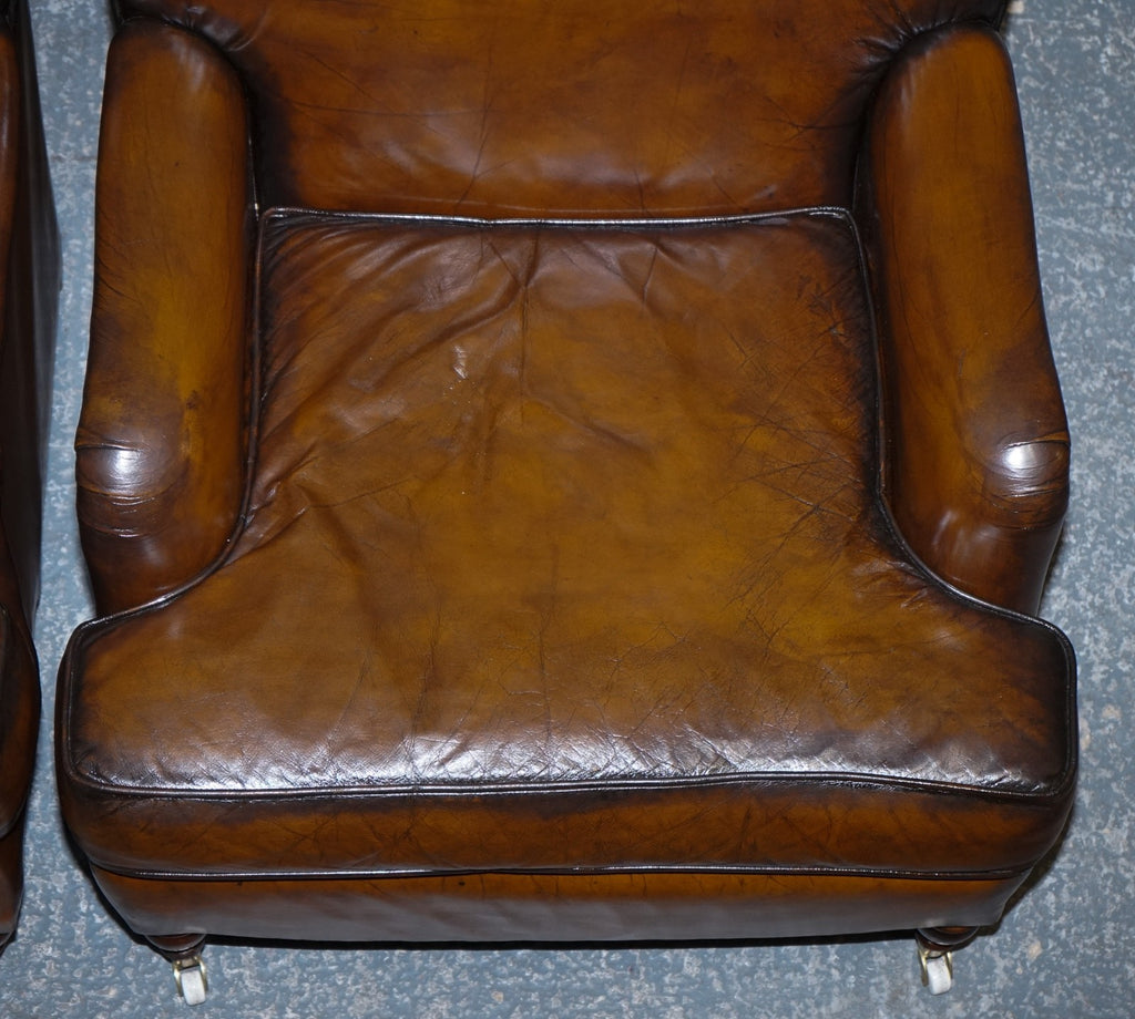 PAIR OF CIGAR HAND DYED LEATHER HOWARD & SONS STYLE ARMCHAIRS ON CASTOR FEET