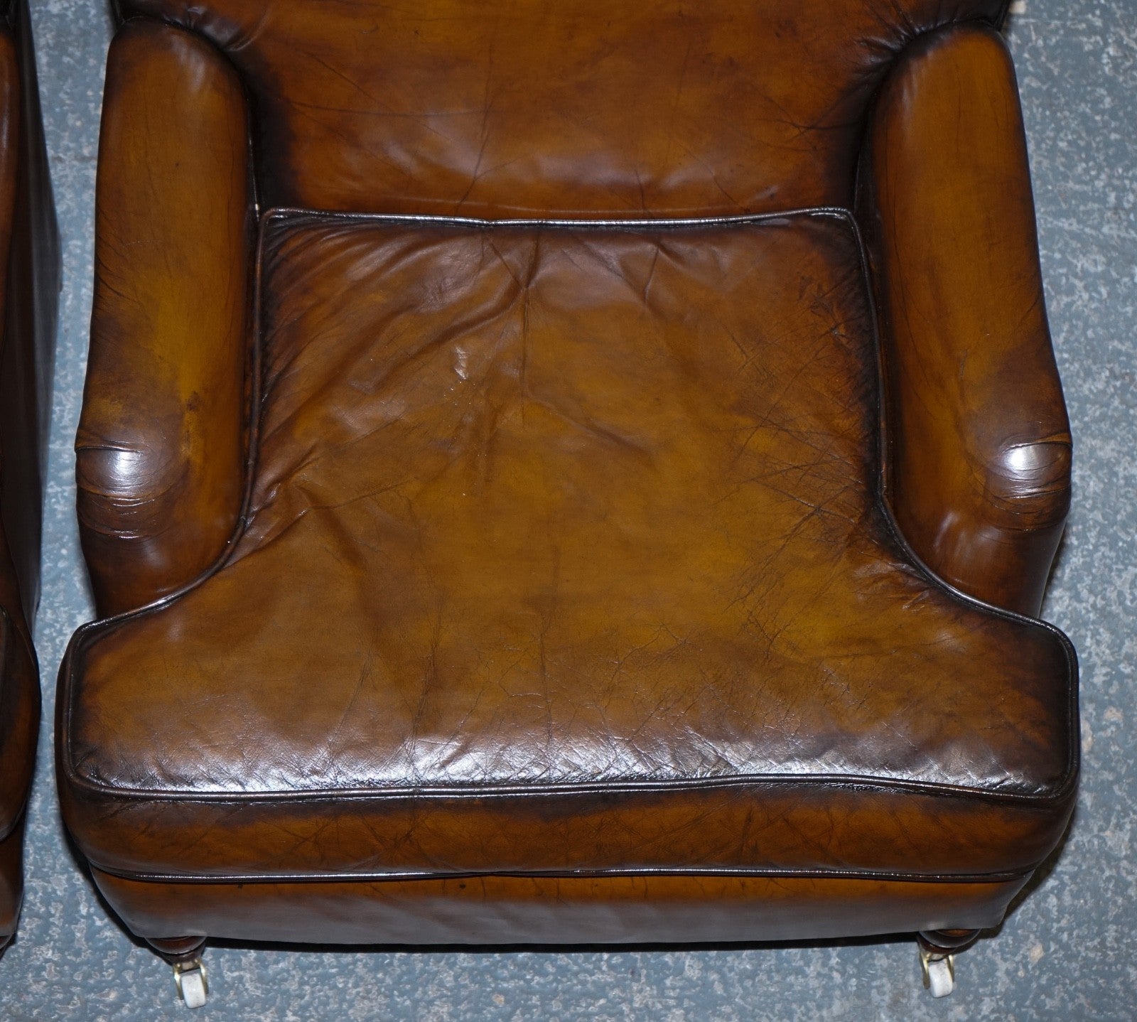 PAIR OF CIGAR HAND DYED LEATHER HOWARD & SONS STYLE ARMCHAIRS ON CASTOR FEET