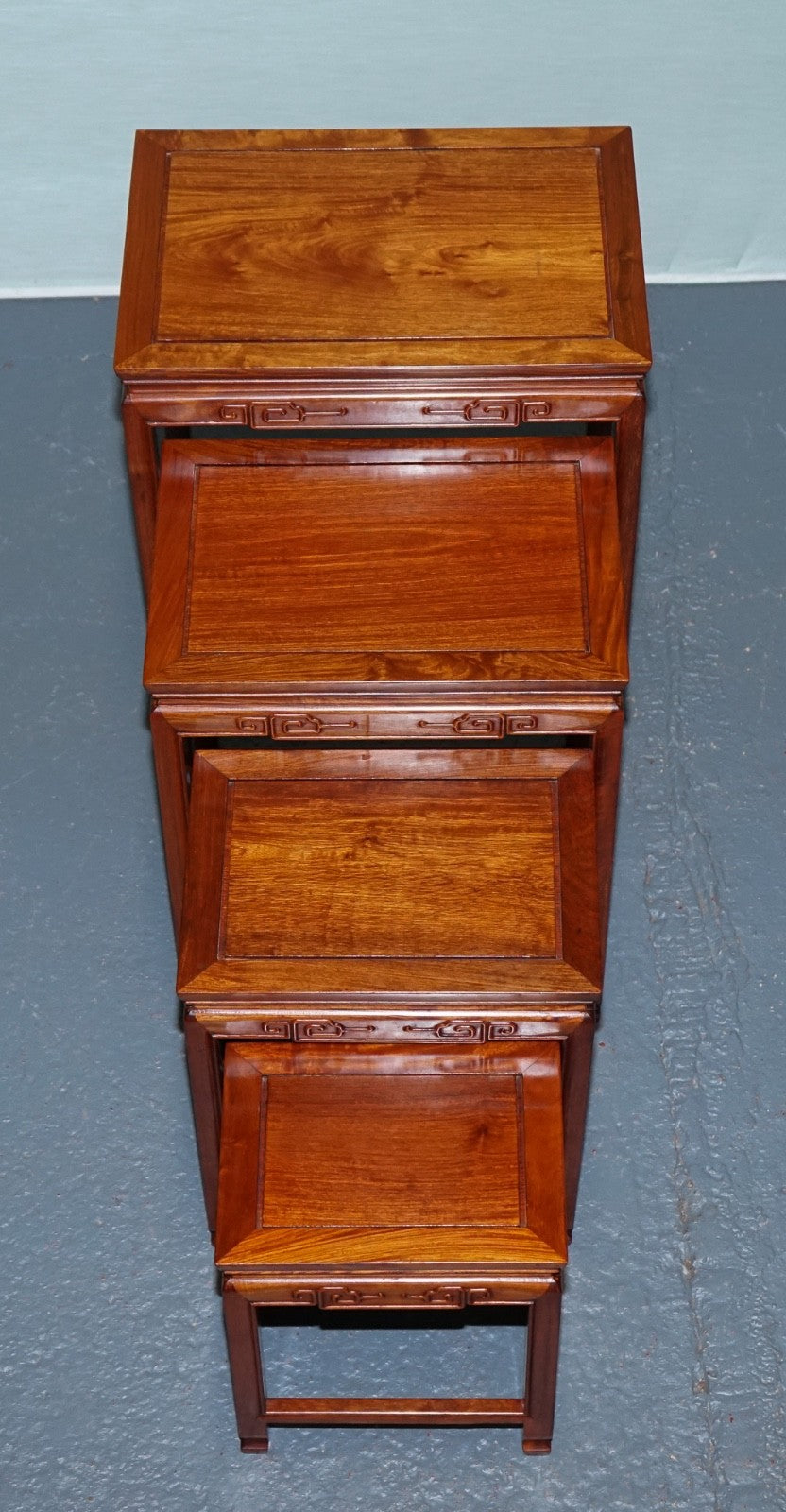 ORIENTAL CHINESE TEAK NEST OF FOUR TABLES WITH CARVED DETAILS