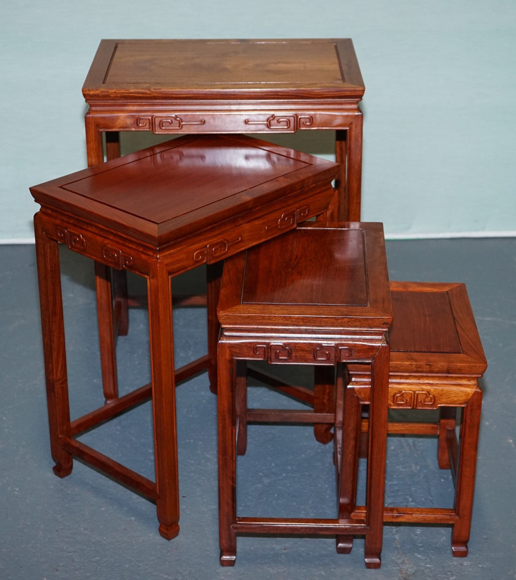 ORIENTAL CHINESE TEAK NEST OF FOUR TABLES WITH CARVED DETAILS