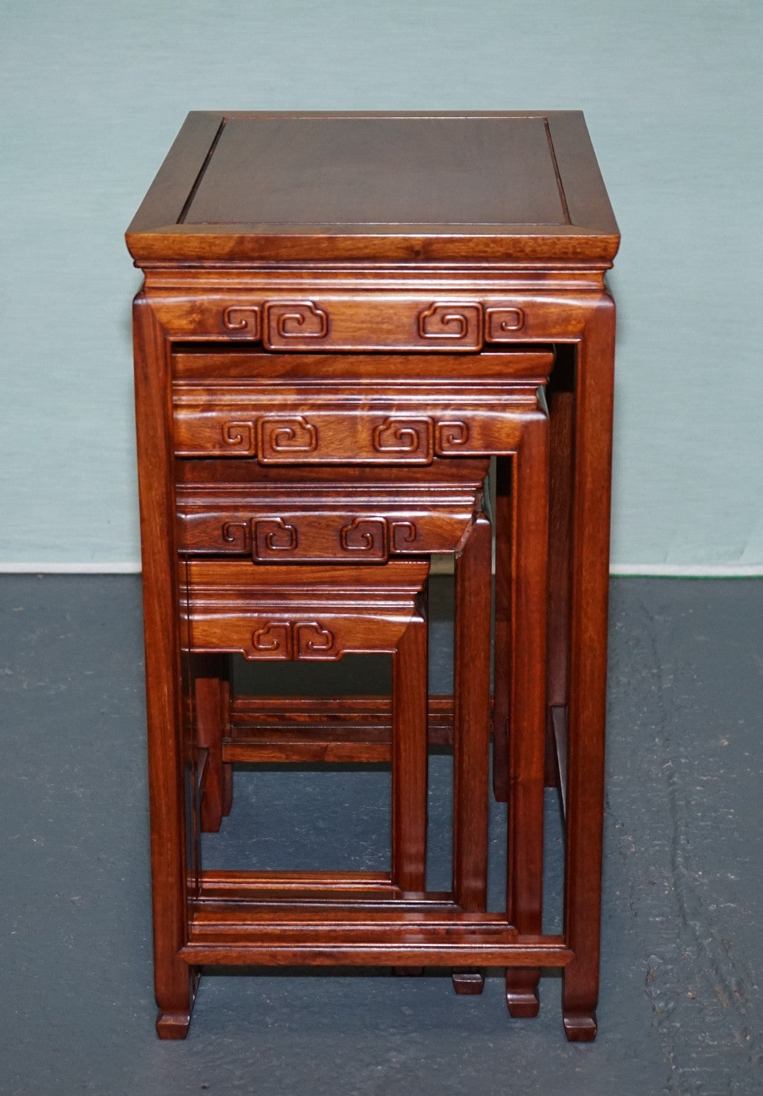 ORIENTAL CHINESE TEAK NEST OF FOUR TABLES WITH CARVED DETAILS