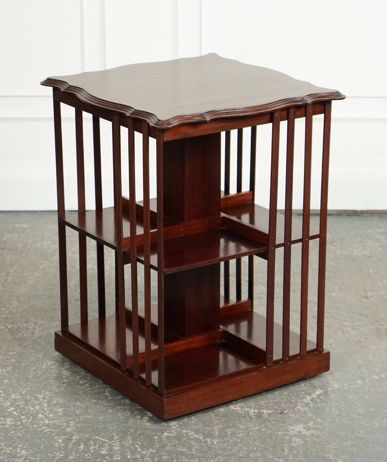 ANTIQUE EDWARDIAN REVOLVING BOOKCASE WITH A SERPENTINE SHAPED TOP