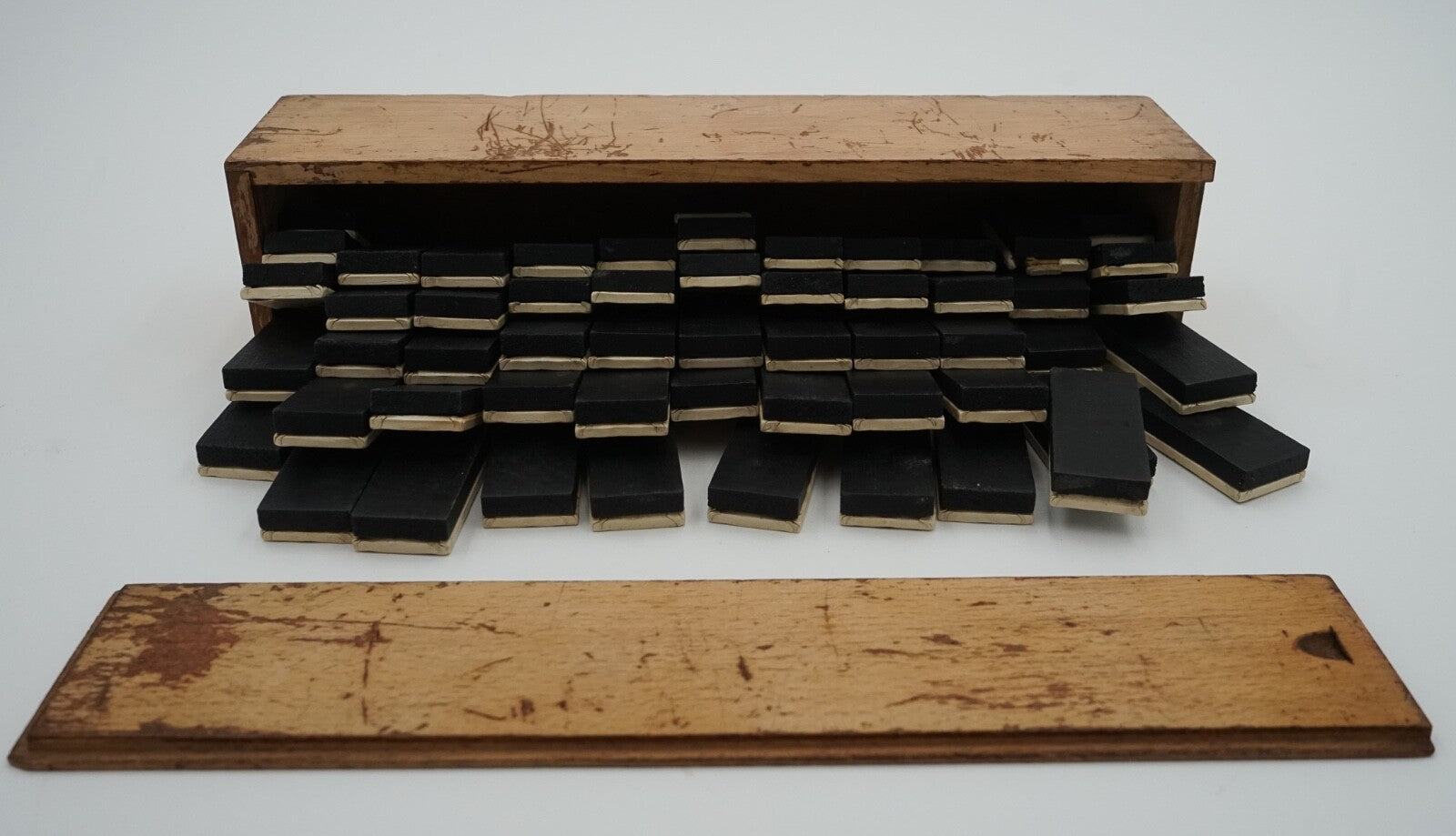 LATE 19TH CENTURY BOX OF TRADITIONAL GAME NINER DOMINOS WITH STUNNING PATINA